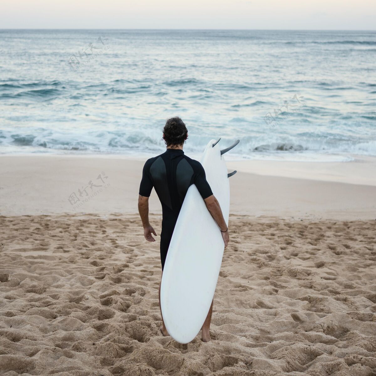 夏季穿着冲浪服的男人从后面走在沙滩上冒险冲浪生活方式