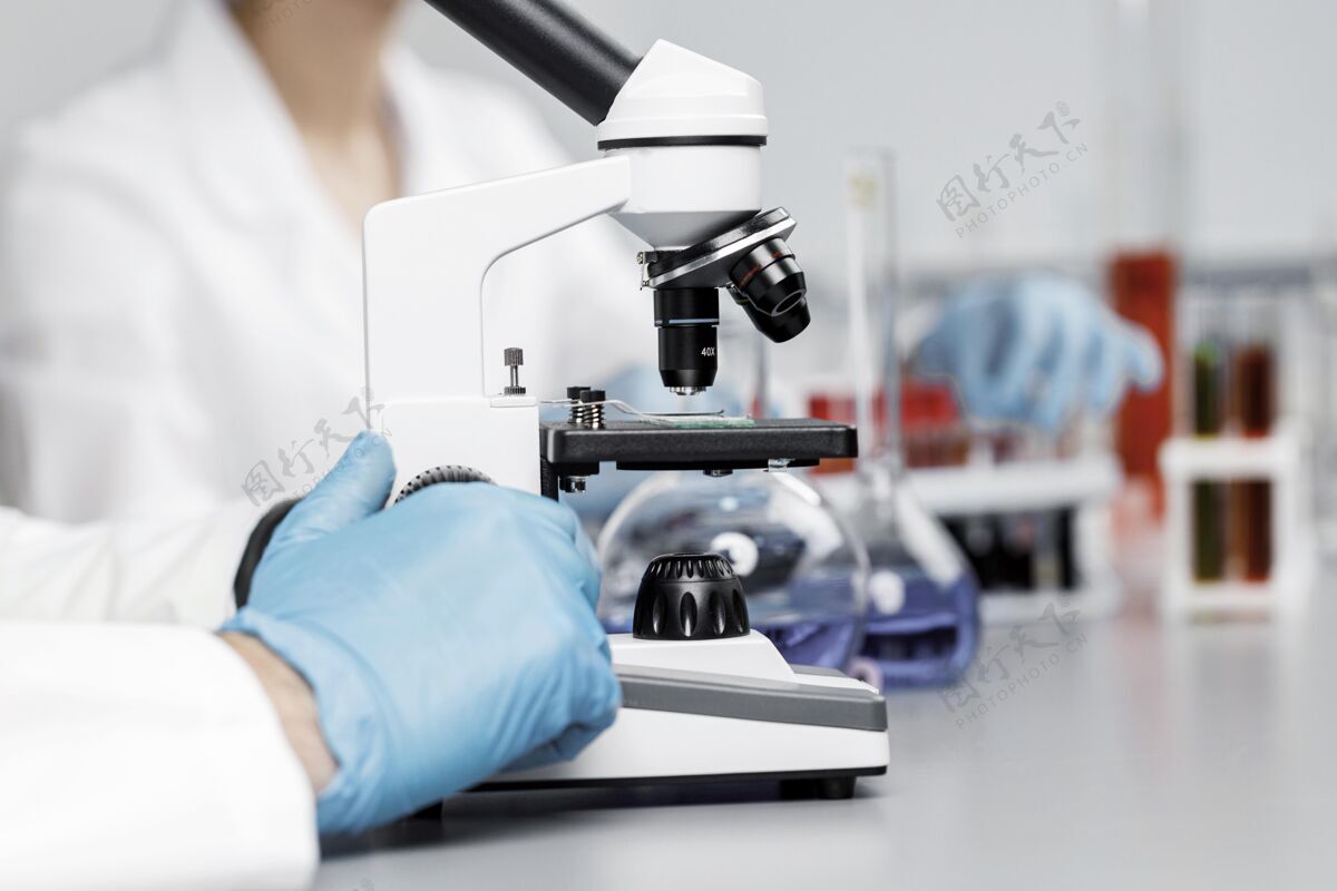 科学家戴着手套和显微镜在实验室的女研究员知识分子创新技术员