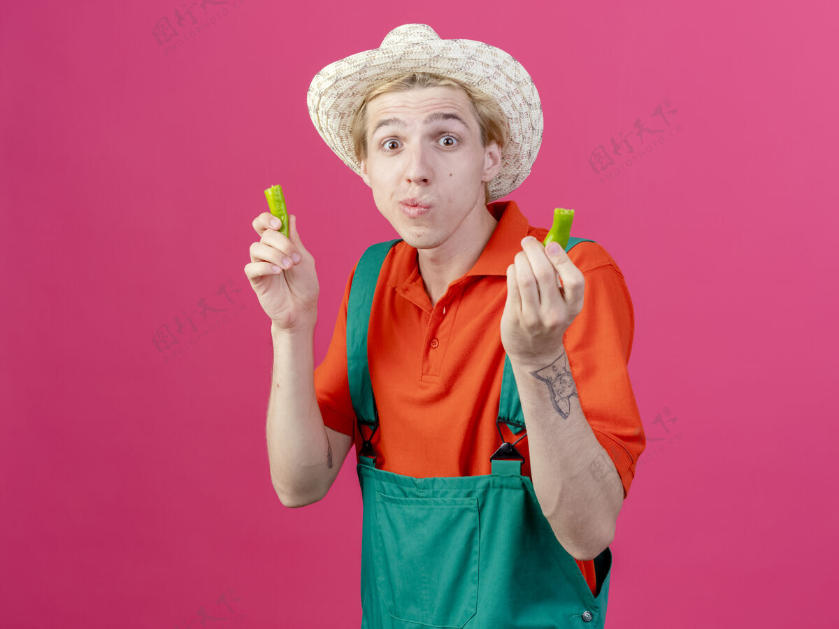 半身年轻的园丁 穿着连体衣 戴着帽子 手里拿着一半的青椒帽子年轻绿色