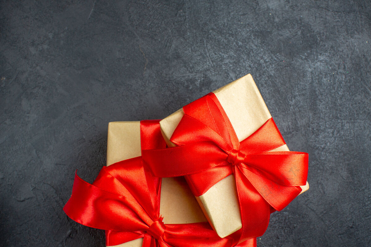 购物圣诞背景与美丽的礼物与蝴蝶结形丝带在黑暗的背景蝴蝶结轮子蝴蝶结