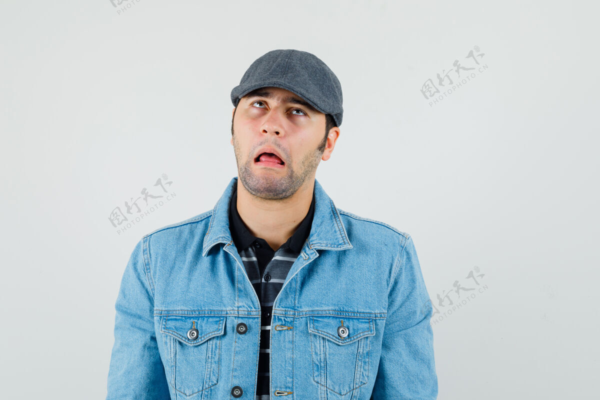 现代一个穿着t恤 夹克 帽子 满脸滑稽的年轻人 看上去很粗心帽子男休闲