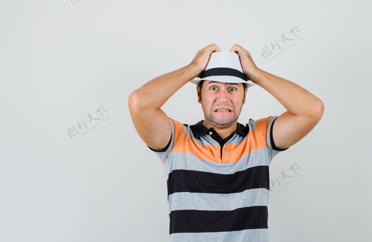 男性一个穿着t恤 戴着帽子 手放在头上的年轻人看起来很烦恼胡茬朋友男人