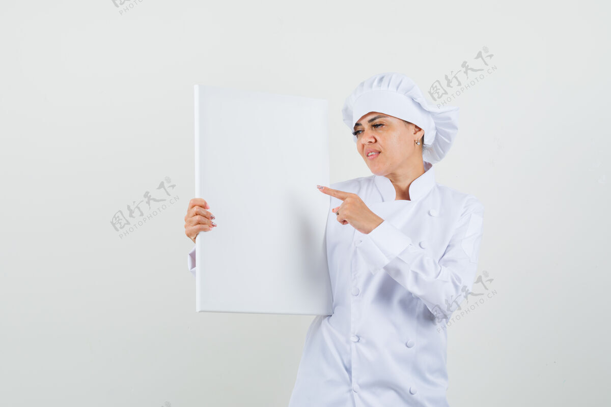 工业女厨师指着白色制服的空白画布餐厅厨师亚洲