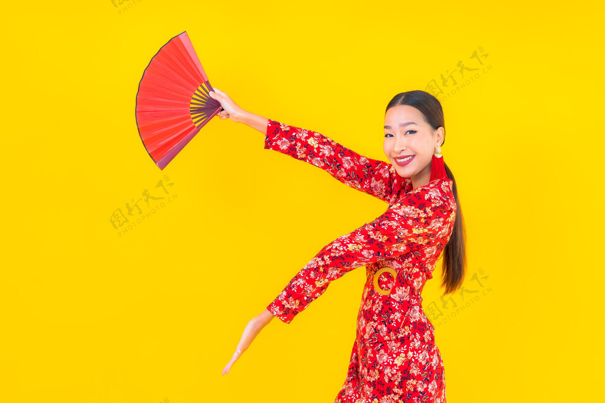 观点美丽的亚洲年轻女子在彩色墙上的中国新年概念中的微笑春天东方人红包