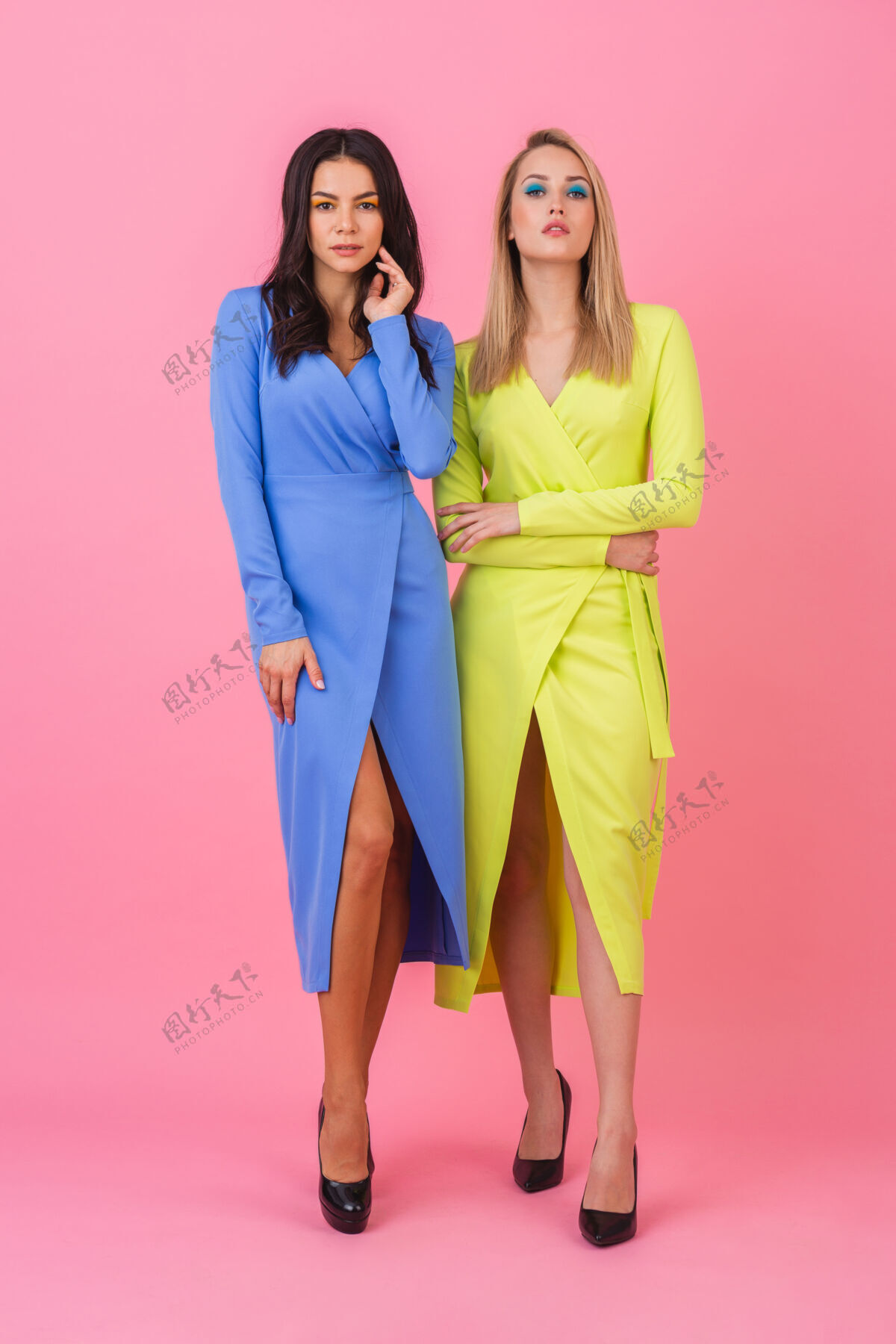 夹克两位时尚性感迷人的女士身着蓝黄相间的时尚多彩连衣裙 在粉色墙壁上摆出了一副丰满的姿势 夏日时尚潮流年轻休闲外观