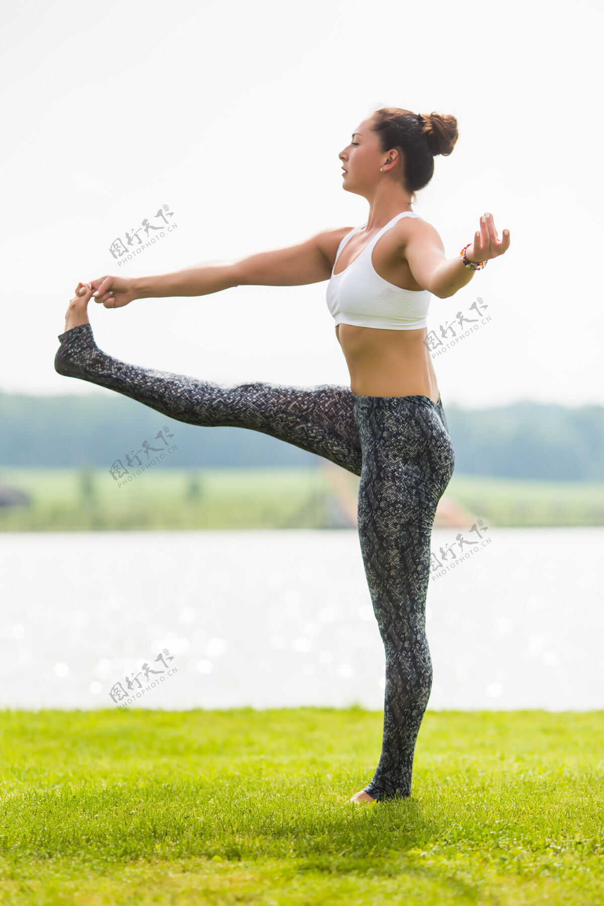 女性年轻的女人在阳光下在公园做瑜伽姿势人放松莲花