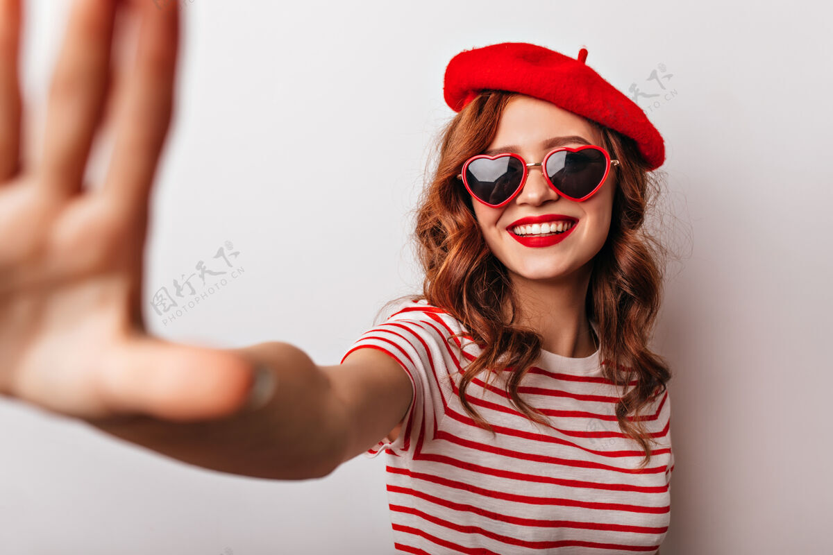 头发无忧无虑的法国女模特戴着贝雷帽微笑着情绪化的女孩在休闲配饰中摆姿势配饰表情时尚