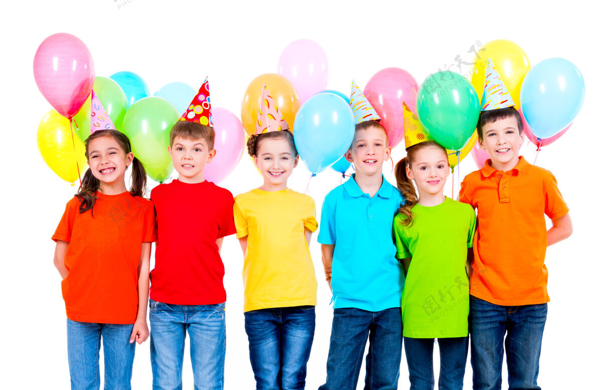 乐趣一群微笑的孩子穿着彩色t恤 头戴派对帽 白色墙上挂着气球庆祝孩子同学