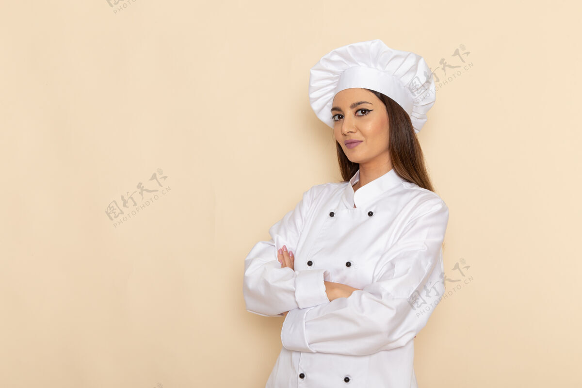 护士身着白色厨师服的年轻女厨师在浅白的墙上微笑着摆姿势微笑工作套装