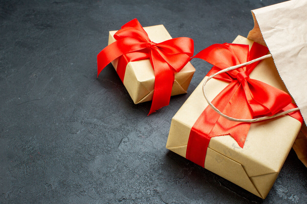 圣诞节在一张深色的桌子上用红丝带近距离观看美丽的礼物购物包装景观