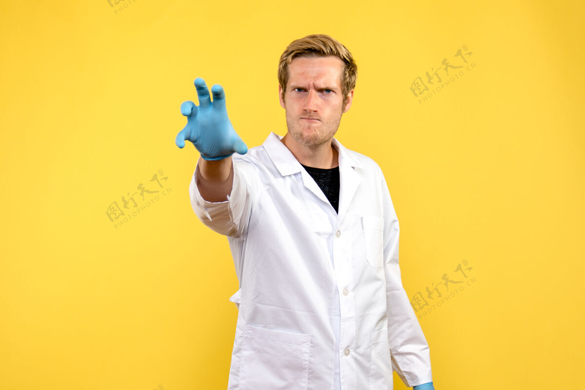 愤怒正面图黄色背景上怒容满面的男医生健康医疗科维德-大流行肖像制服实验室