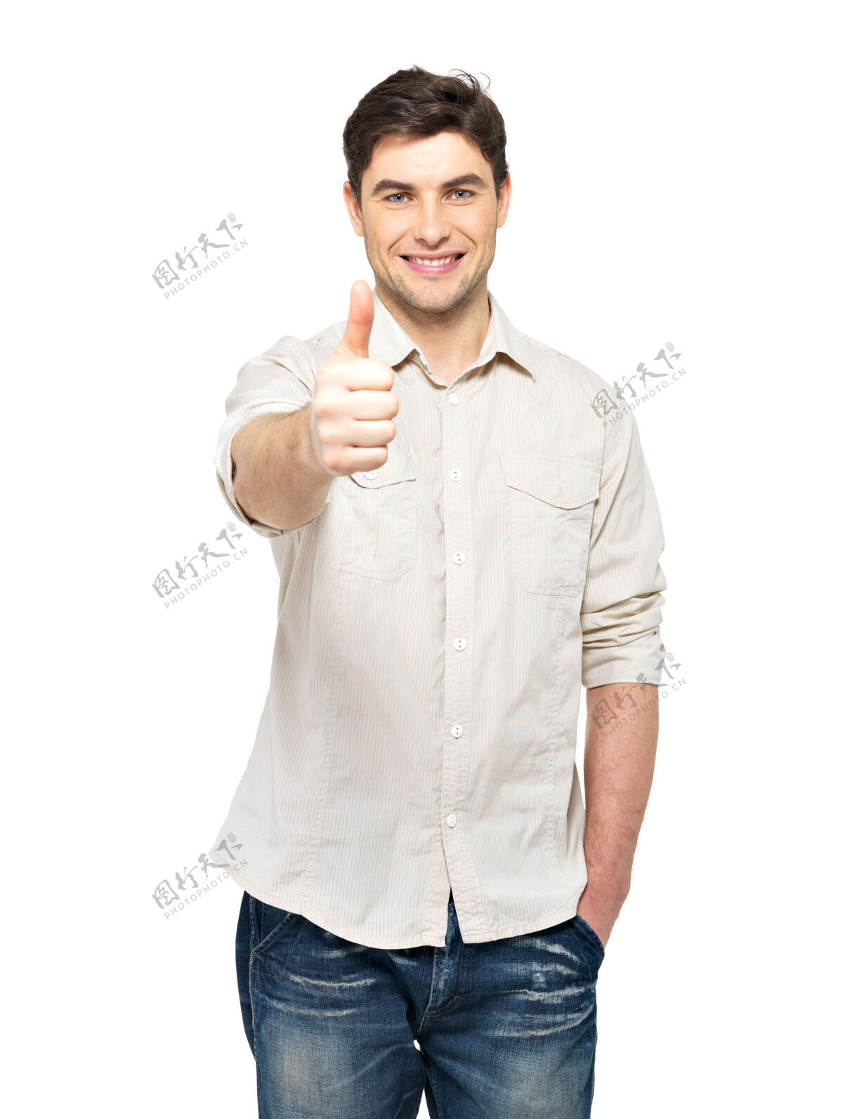 看年轻快乐的男人竖起大拇指 在白色的墙壁上随意地贴着牌子大拇指光男人