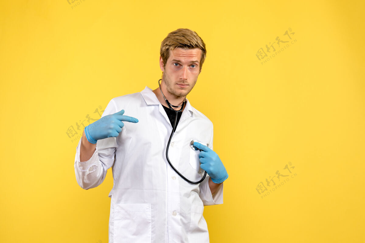 视图正面图黄色背景上的男医生病毒健康情绪医生外套制服药品