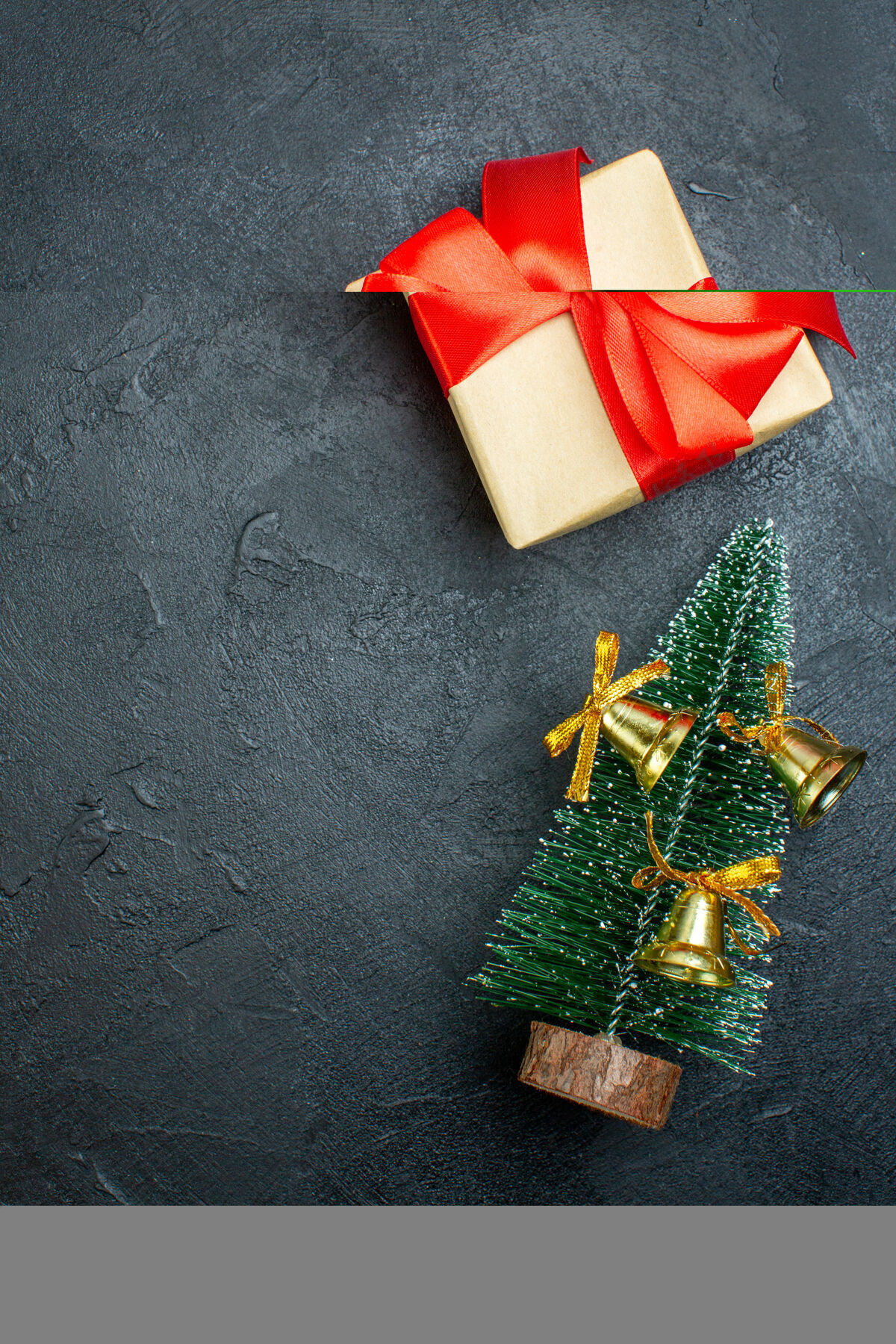 轮子礼品盒的垂直视图 带有蝴蝶结形状的红丝带和装饰的圣诞树o黑色背景视图礼品盒弓形