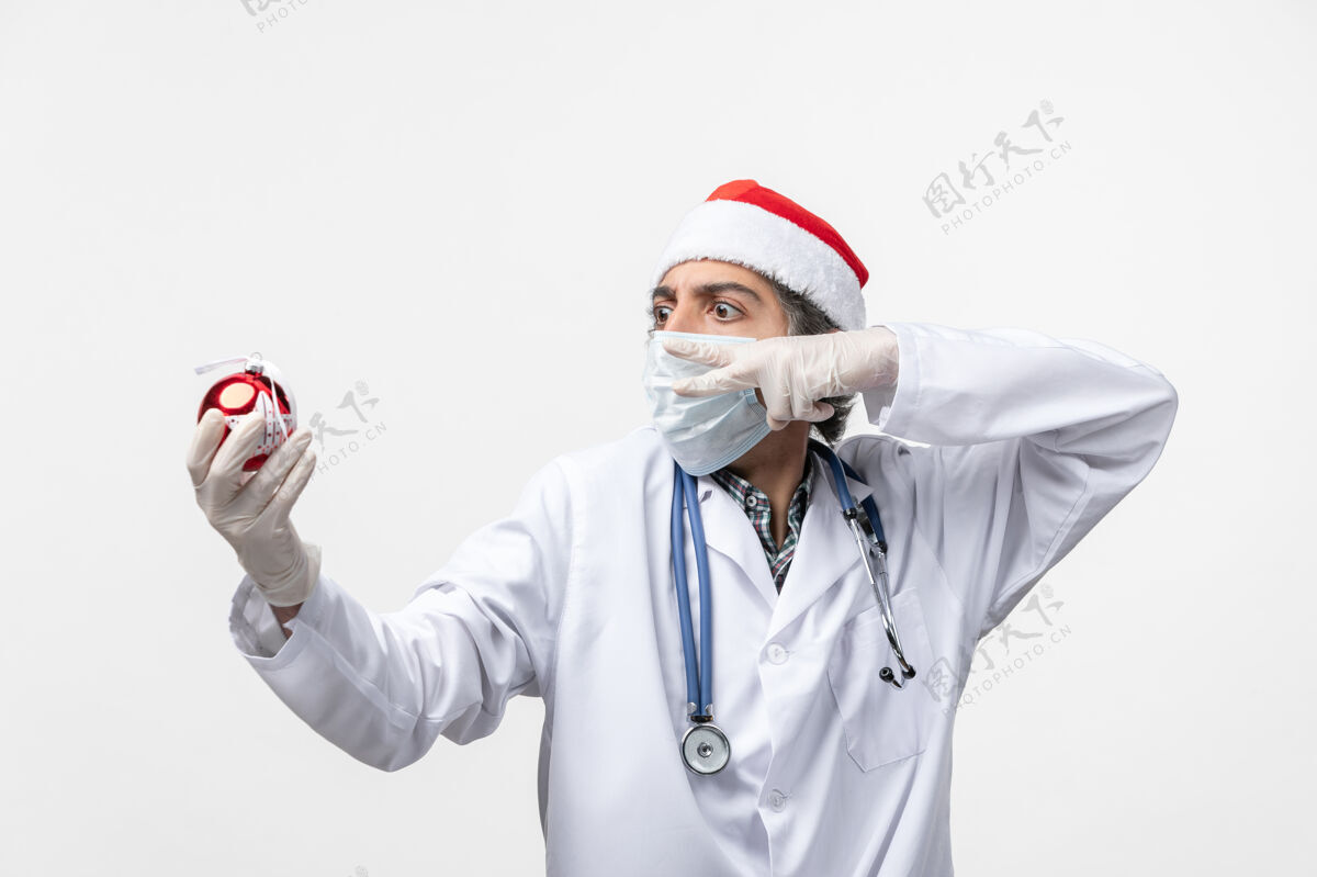 男人正面图男医生手持新年树玩具健康冠状病毒听诊器男医生护士