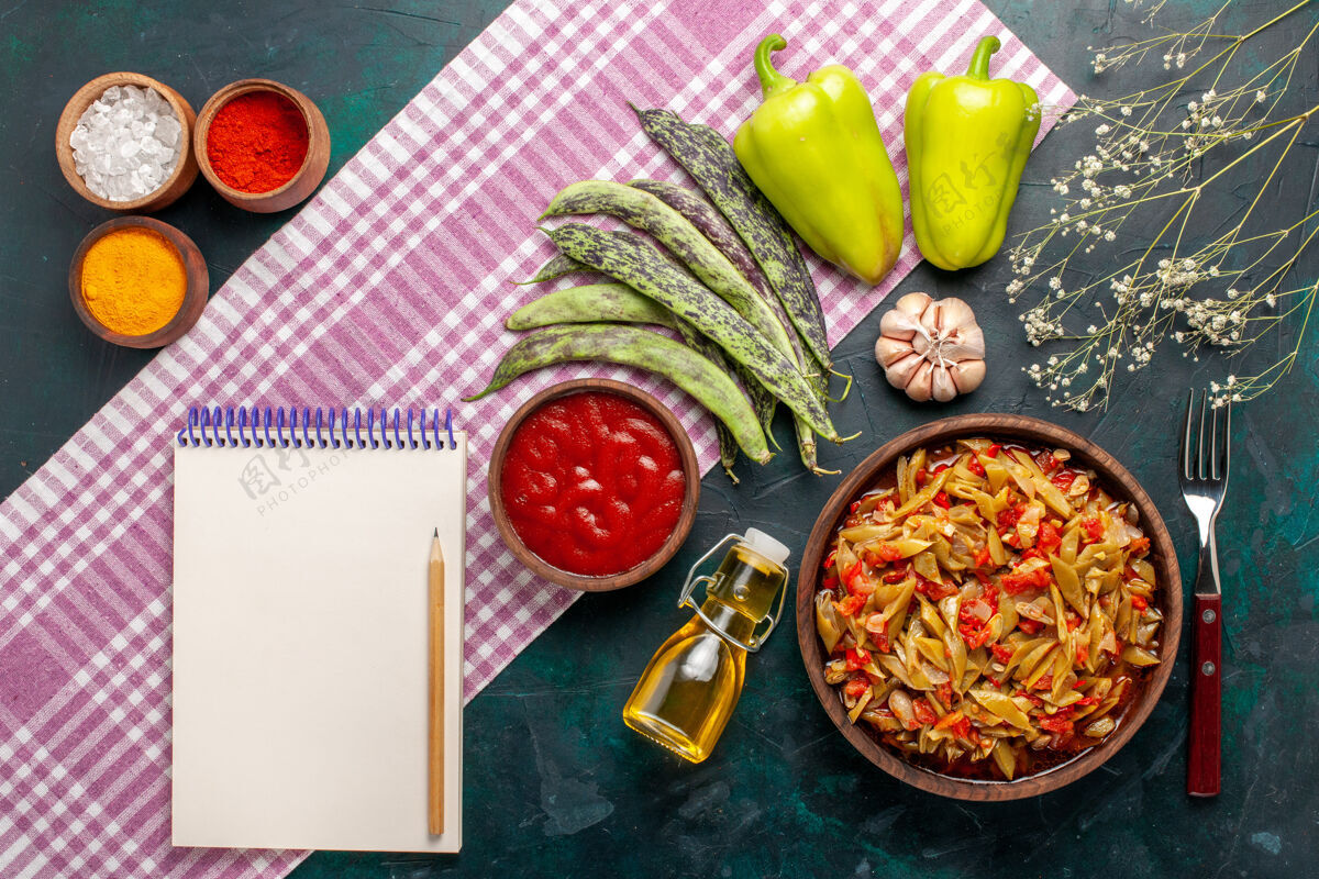 切片俯瞰蓝桌上的蔬菜切片美味豆子餐 配橄榄油和调味品盘子橄榄蔬菜