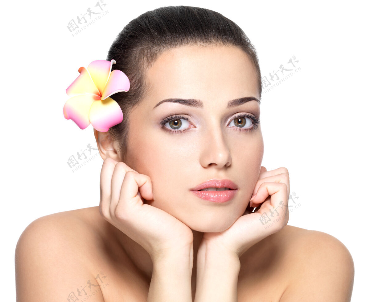 一美丽的年轻女子的脸与花美容治疗的概念肖像在白色的背景百合花帮宝适触摸