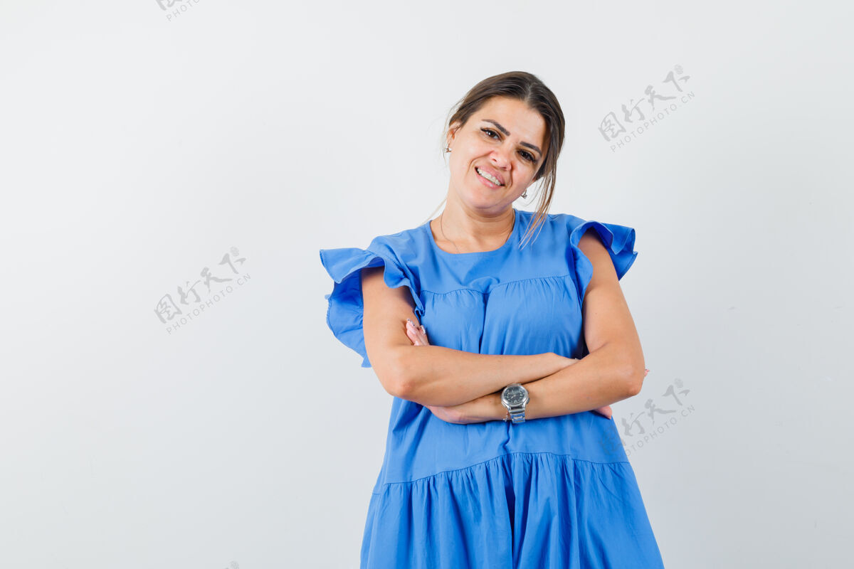 交叉穿蓝色衣服的年轻女子交叉着双臂站着 看上去很高兴快乐微笑肖像