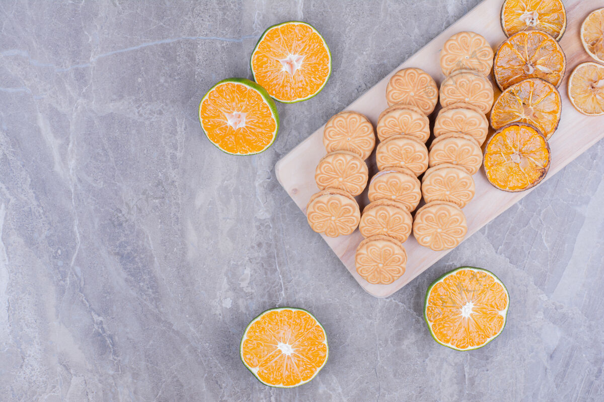 饼干放在木板上的饼干 周围是橘子片香草地壳甜点