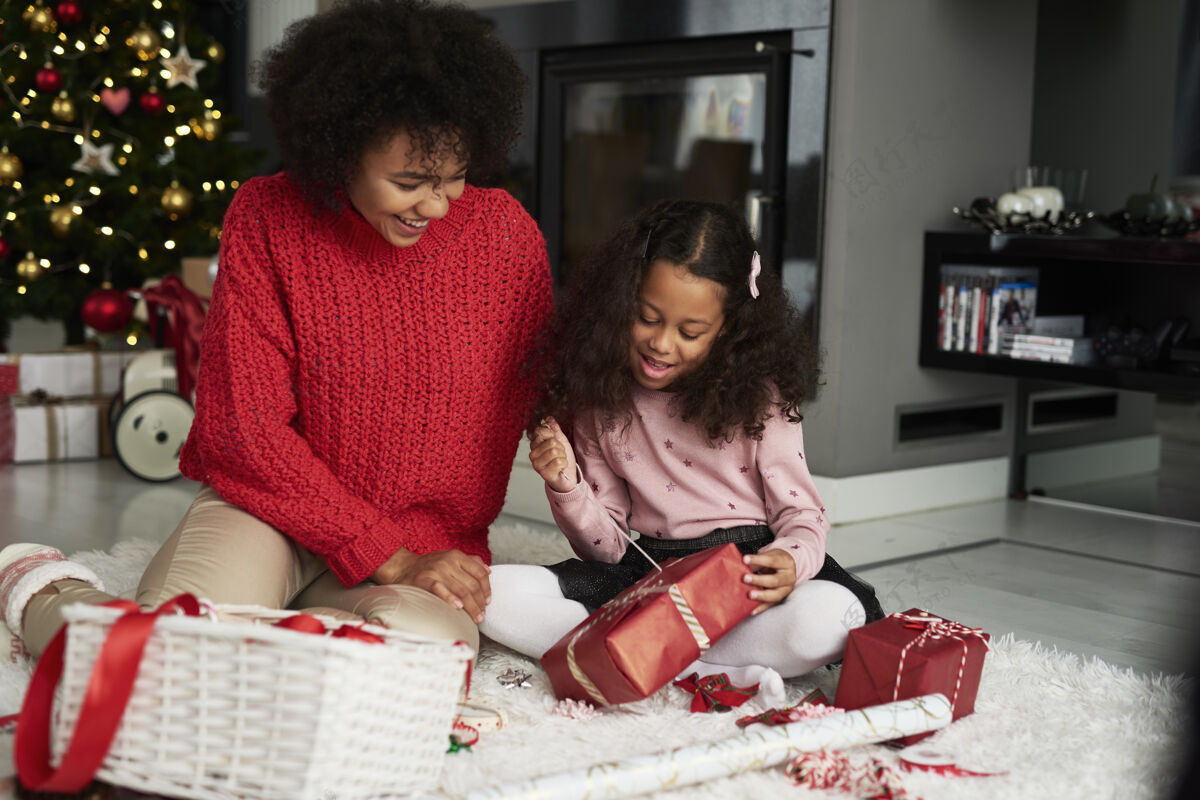 圣诞树女人和她的女儿在包装圣诞礼物包装圣诞装饰品