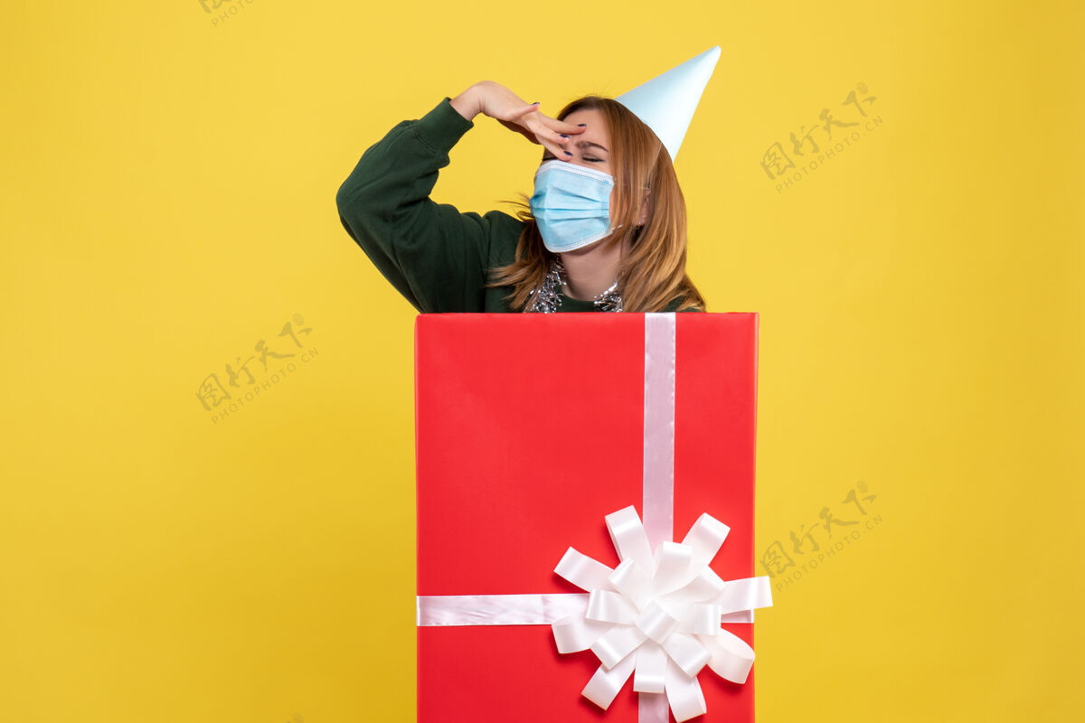 颜色正面图：年轻女性戴着无菌口罩在里面病毒丝带礼物