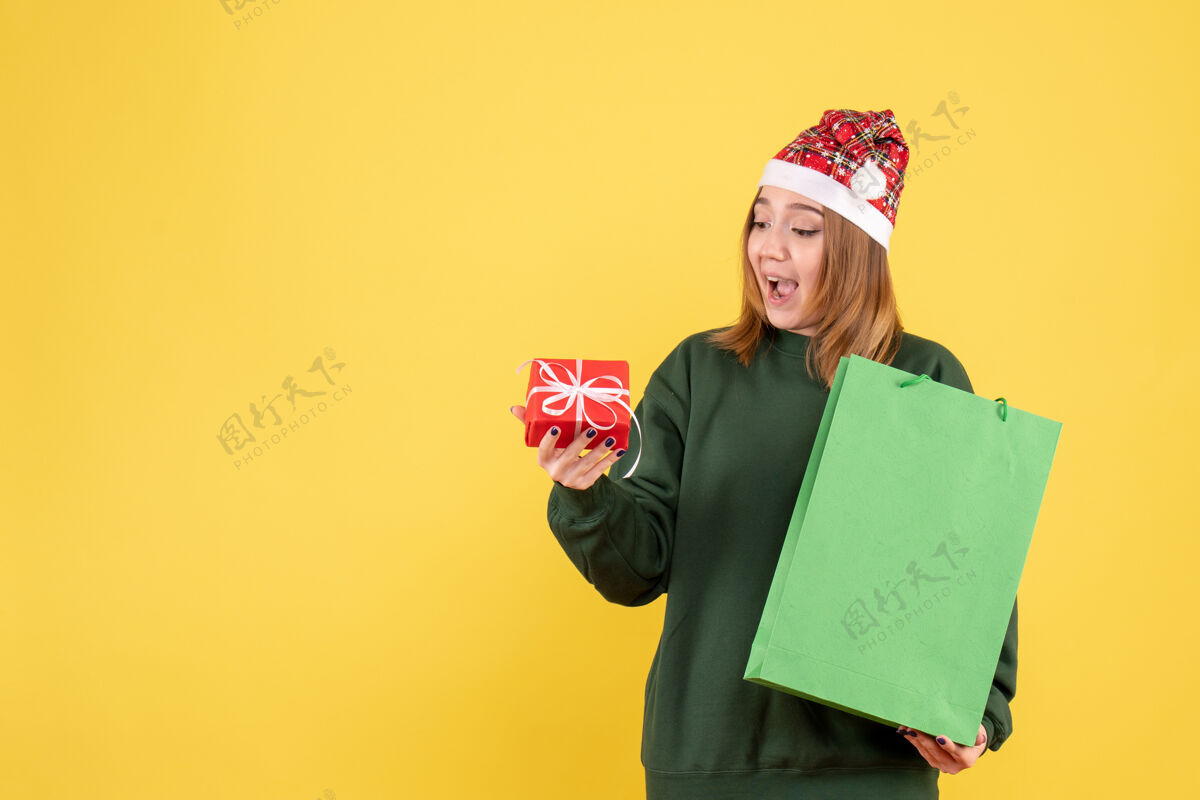 圣诞节正面图：年轻女性 带着小礼物和购物包女人漂亮帽子
