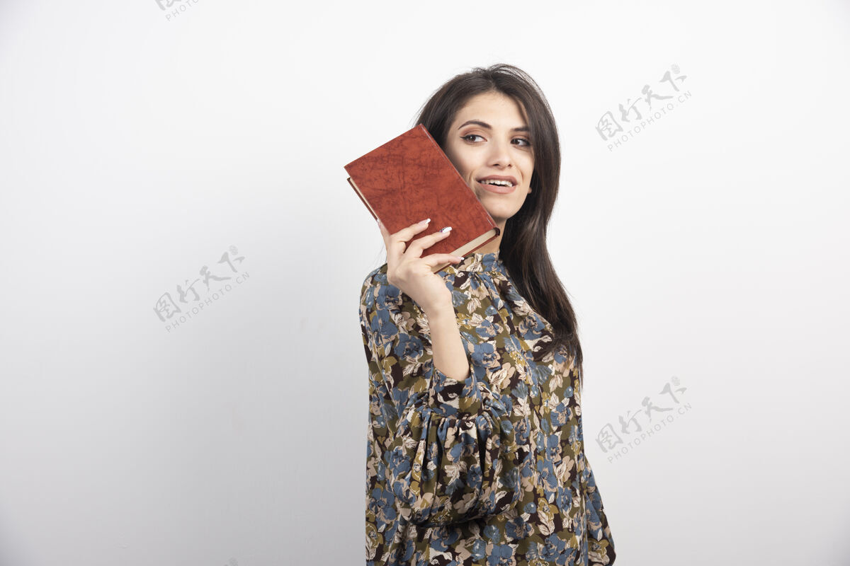 女人微笑的女人拿着书摆姿势书黑发情感