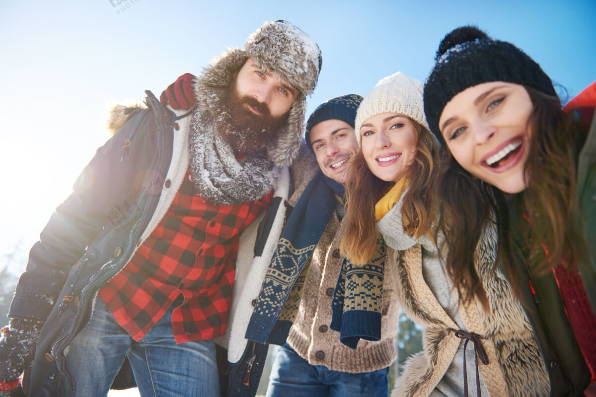 享受雪地里一群朋友的画像度假向上人群