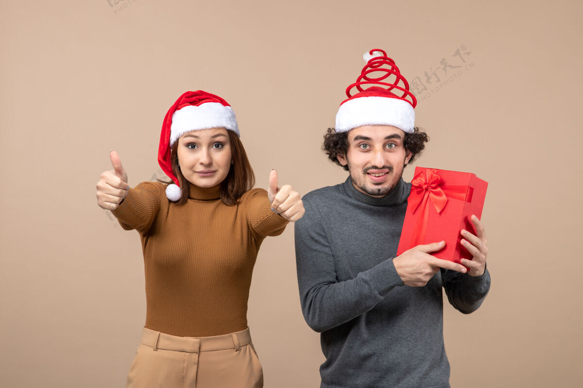 镜头新年气氛喜庆的概念与有趣的快乐可爱的夫妇戴着红色圣诞老人帽的灰色镜头团体孩子心情