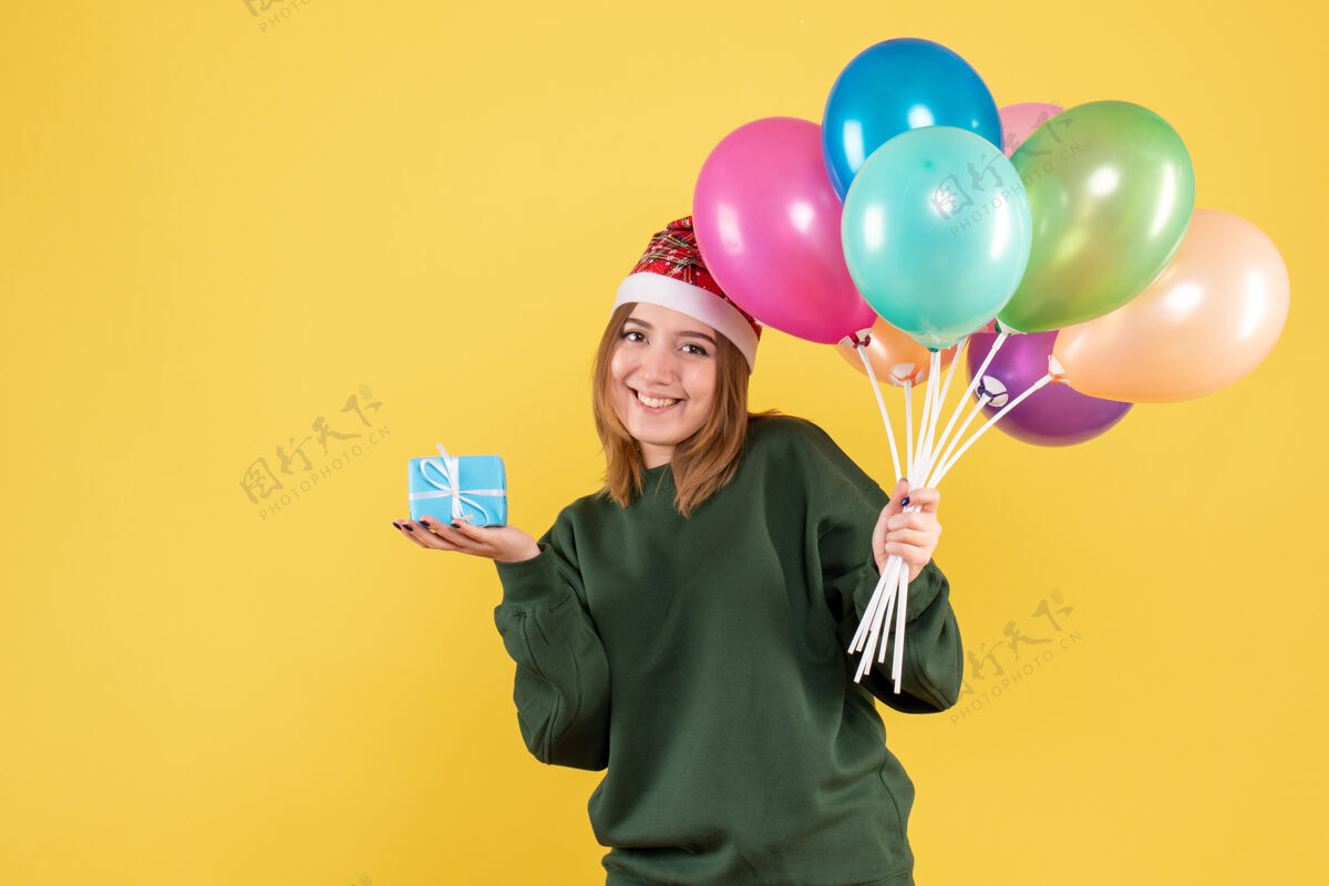 乐趣正面图年轻女性手持气球和小礼物病毒举行年轻女性