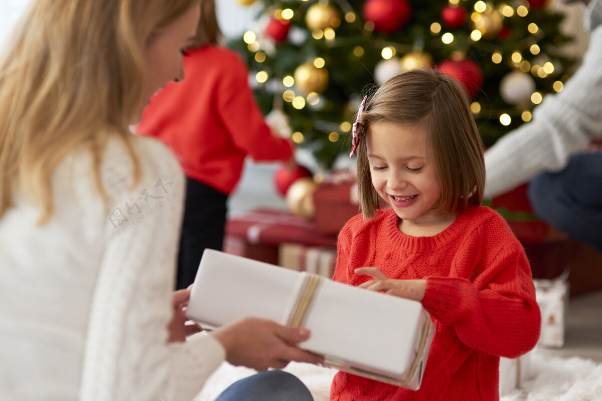 孩子一家人从打开礼物开始过圣诞节节日给予圣诞装饰