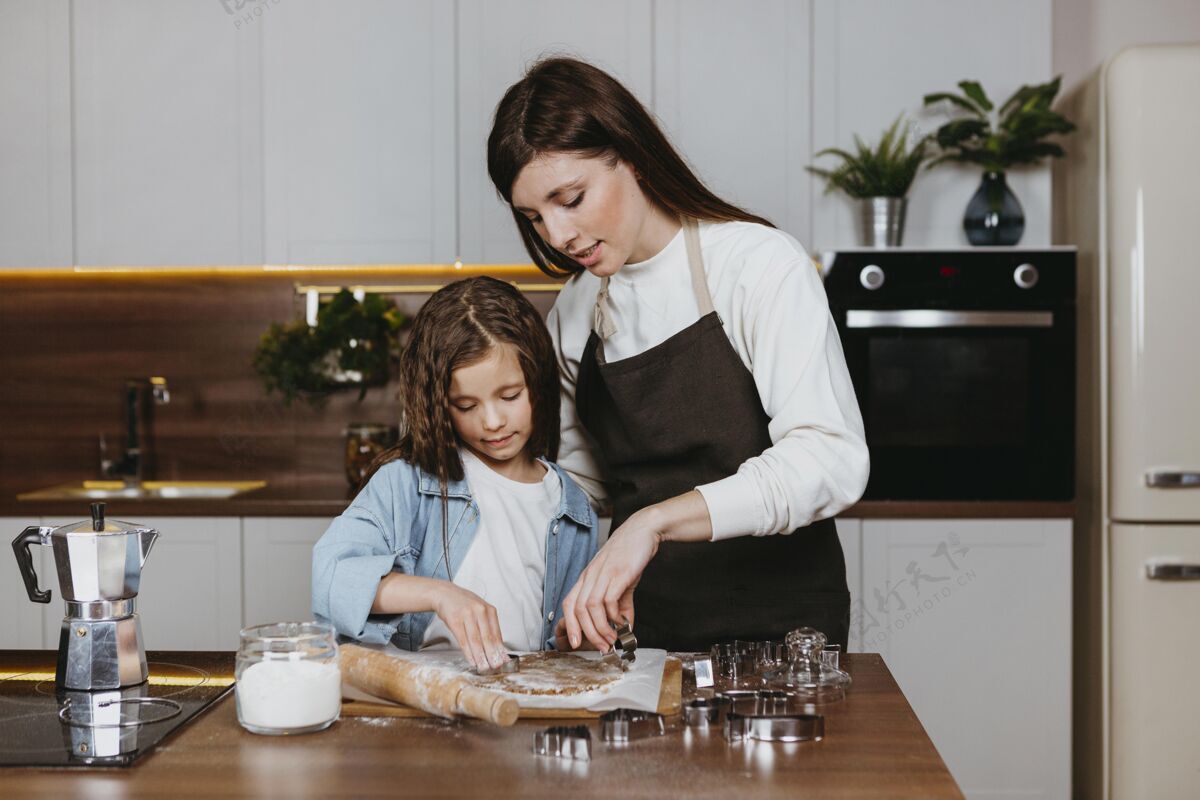 女人母女俩一起在厨房做饭家庭女孩前面