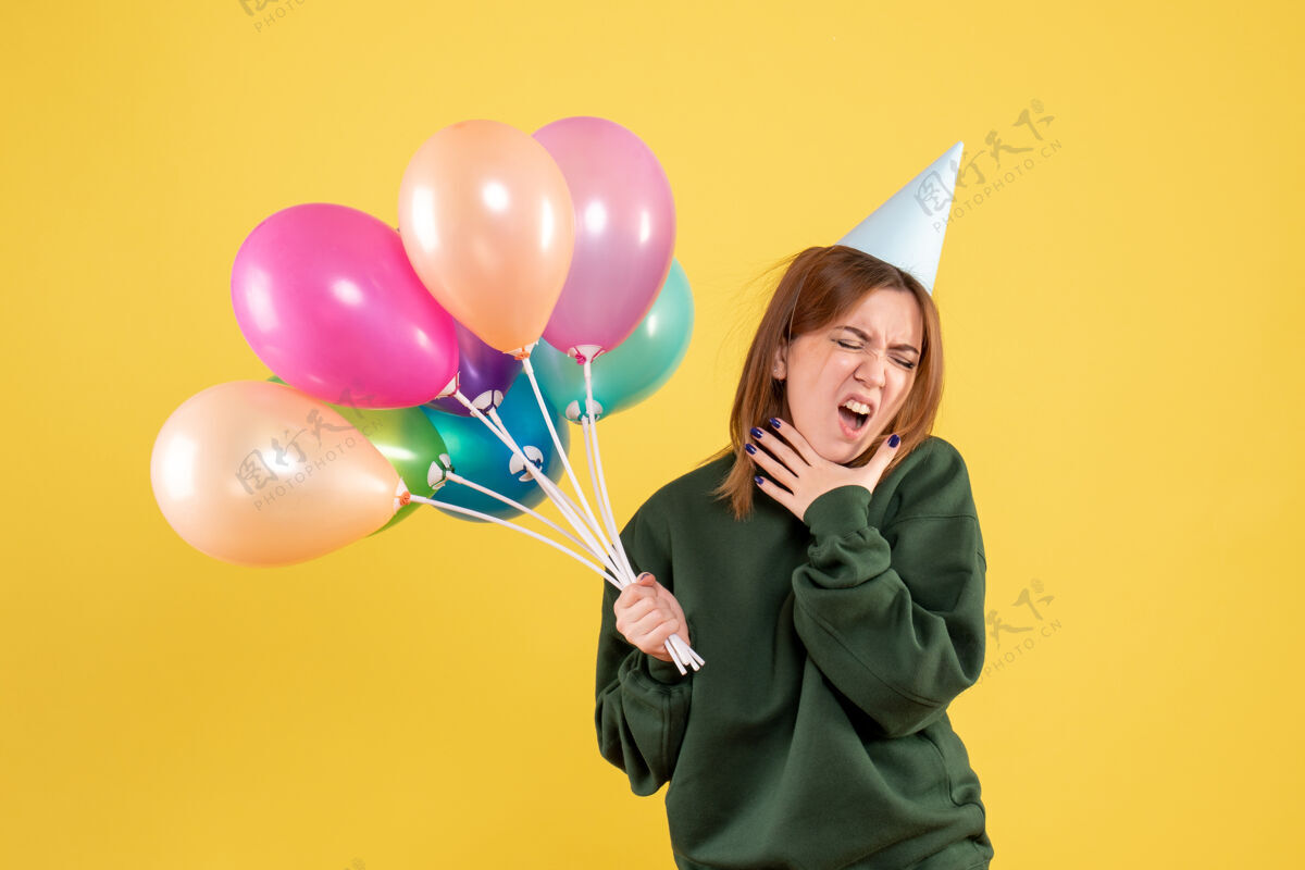 年轻女性正面图：带着彩色气球的年轻女性女性节日年轻