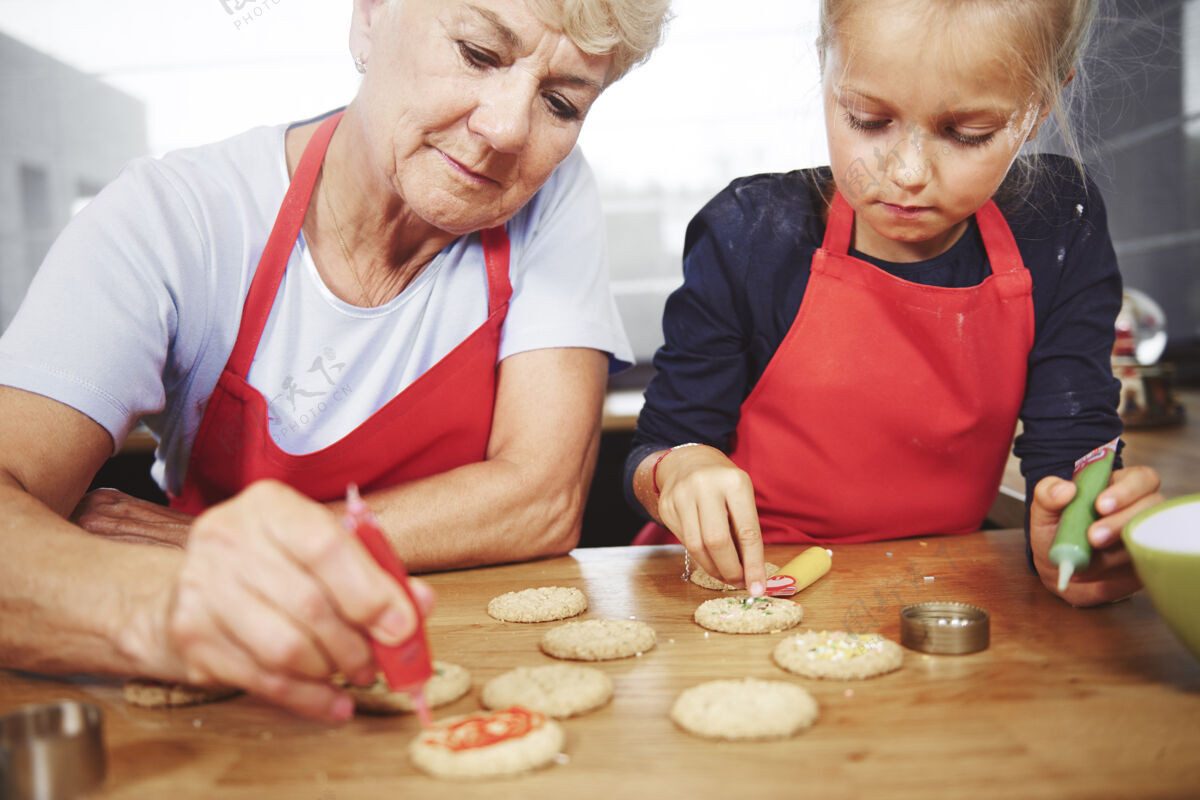 自制奶奶和女孩一起装饰圣诞饼干手装饰厨房