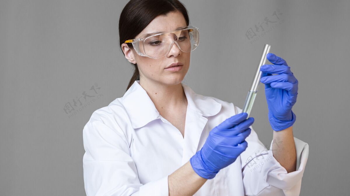 科学前视图的女研究员与安全眼镜举行试管女性调查化学家