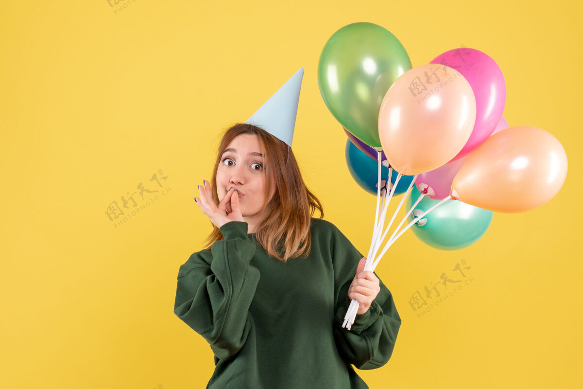 桌子正面图：带着彩色气球的年轻女性乐趣气球气球