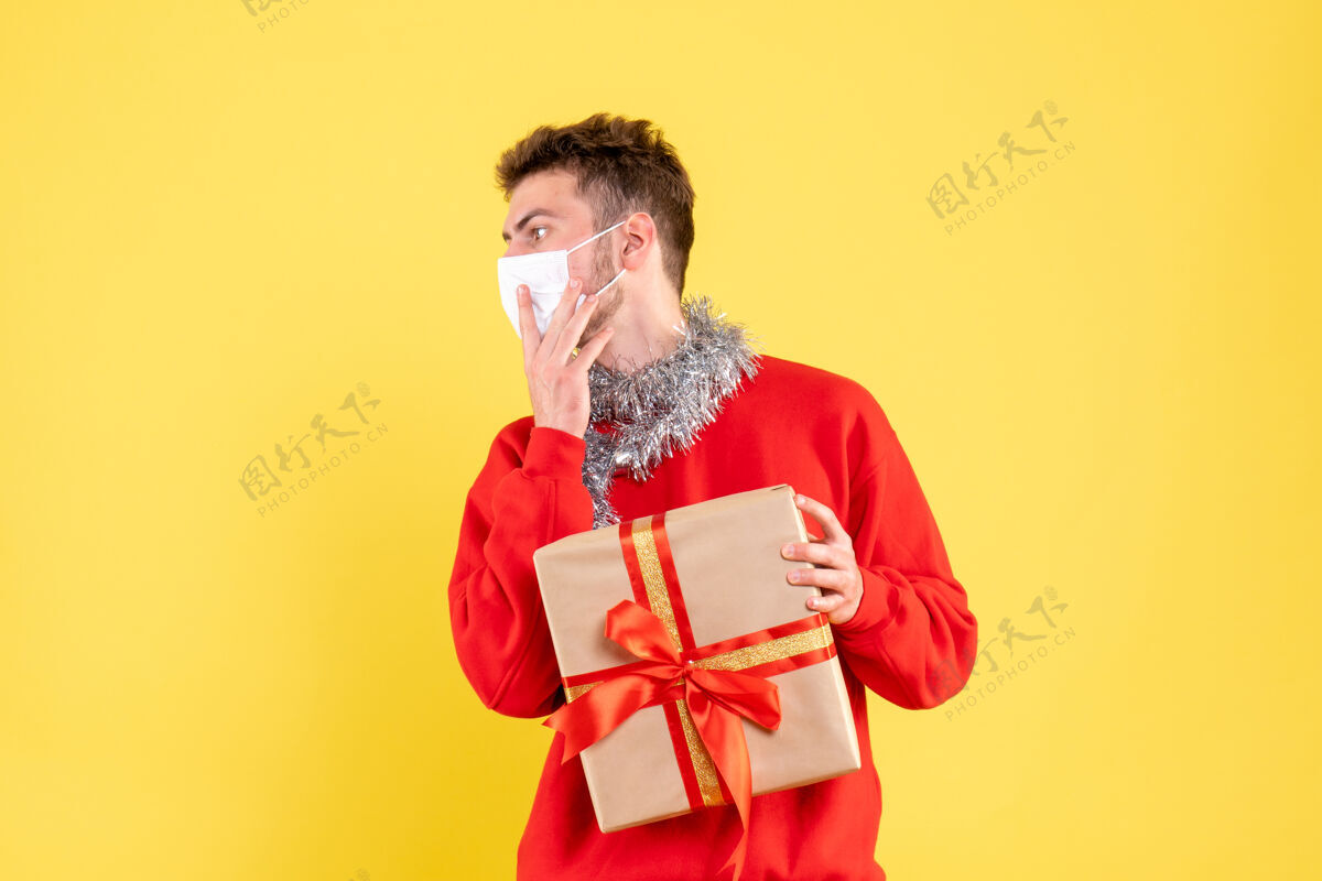 流行病正面图：戴着无菌面具的年轻男性正在过圣诞节人物成人年份