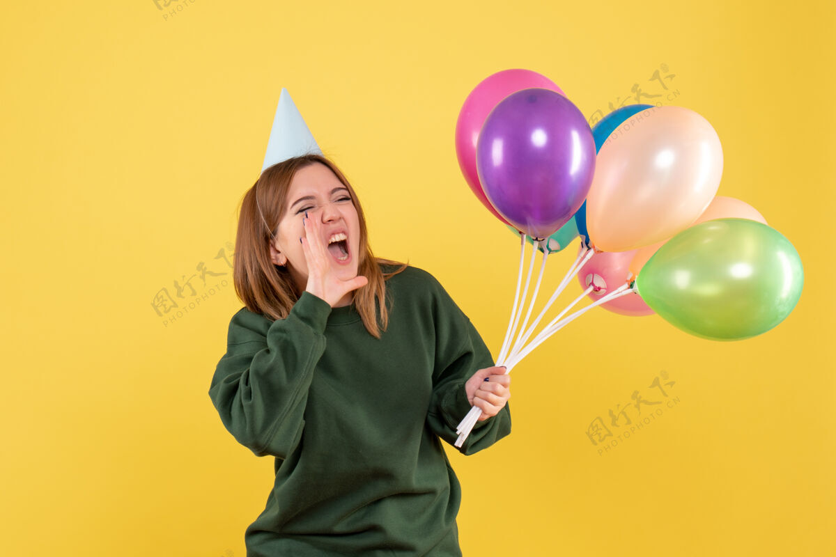 年轻正面图：带着彩色气球的年轻女性气球气球聚会