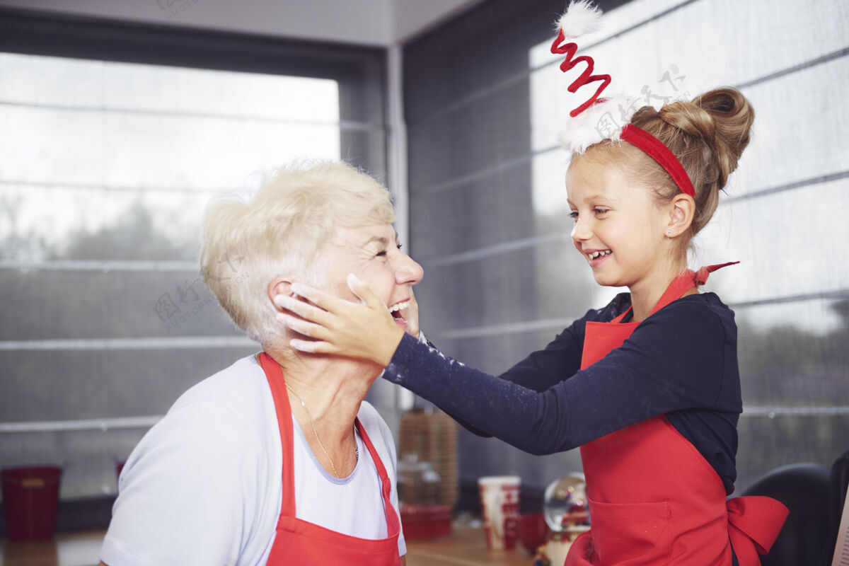 情感孙女在奶奶脸上擦面粉圣诞节脸微笑