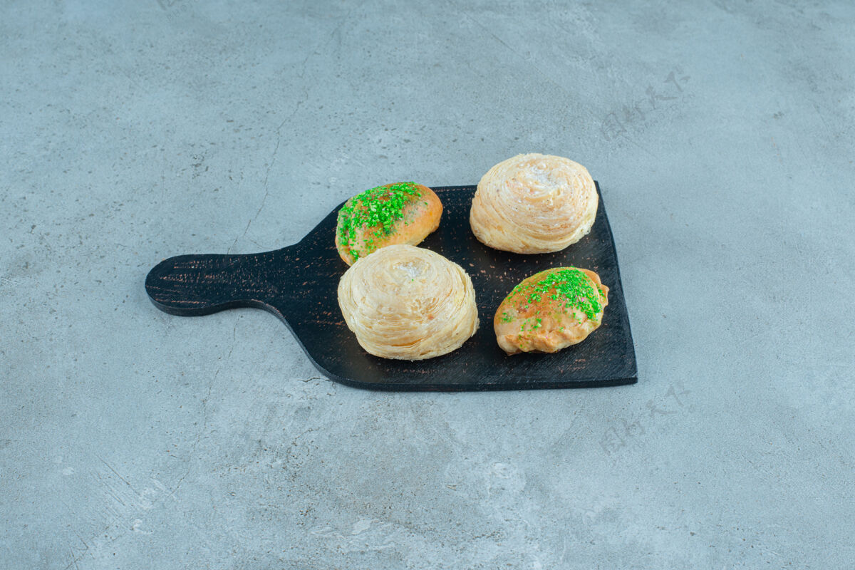 小面包在大理石表面的木板上放上小面包和薄饼甜点馅料美味