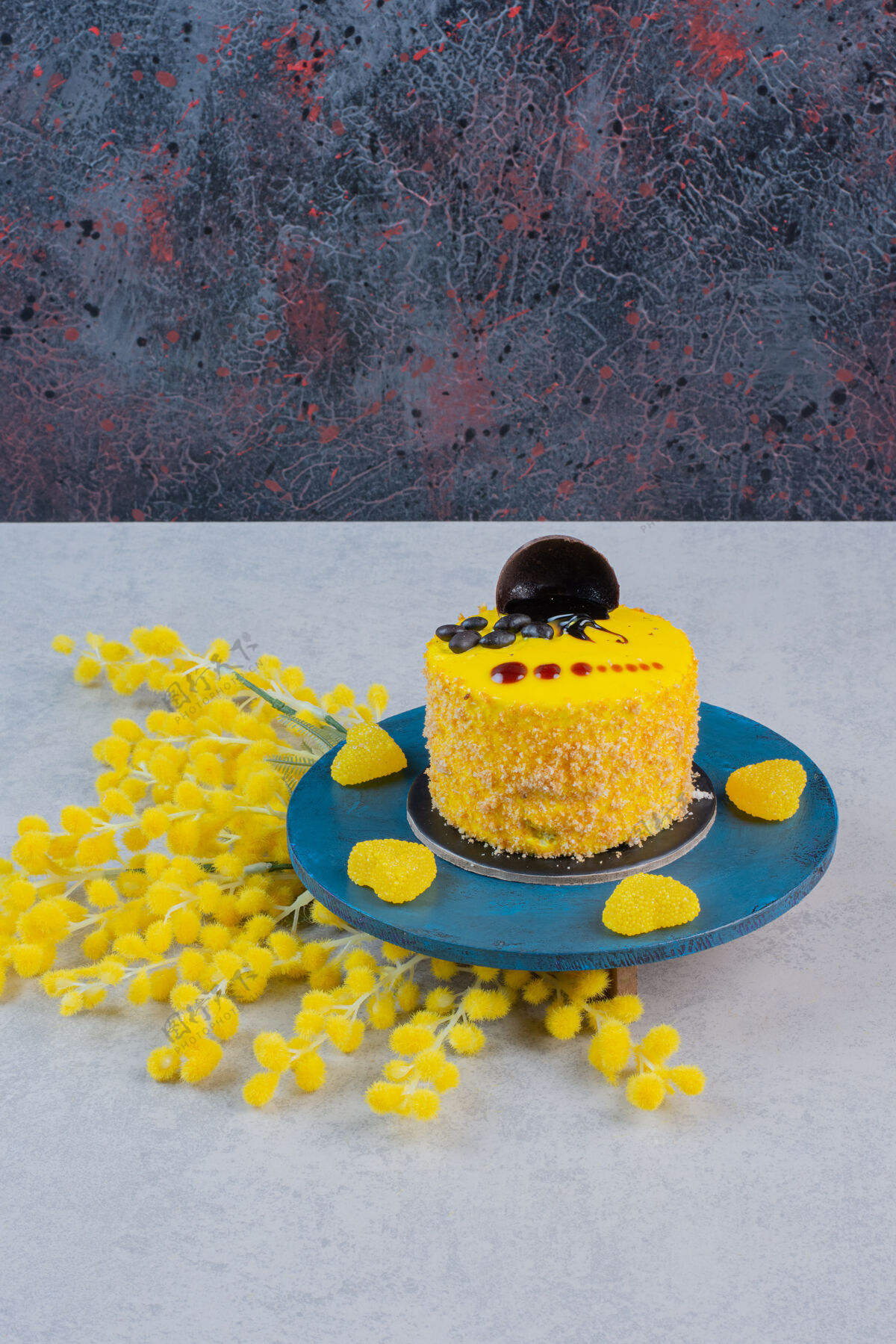 果冻蓝色盘子上的小蛋糕和黄色心形糖果美味蛋糕装饰