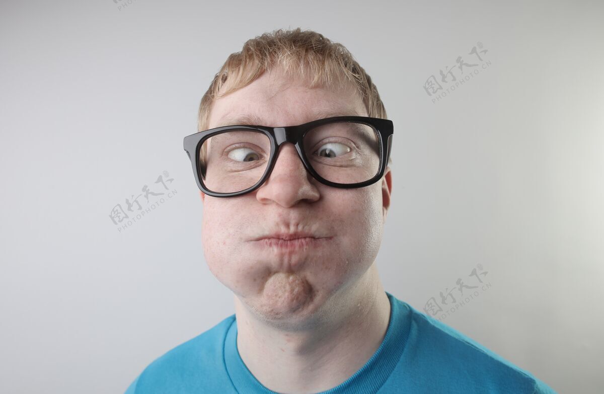 休闲特写镜头中 一位身穿蓝色t恤 戴着眼镜的白人男性做着滑稽的面部动作太阳镜眼睛人