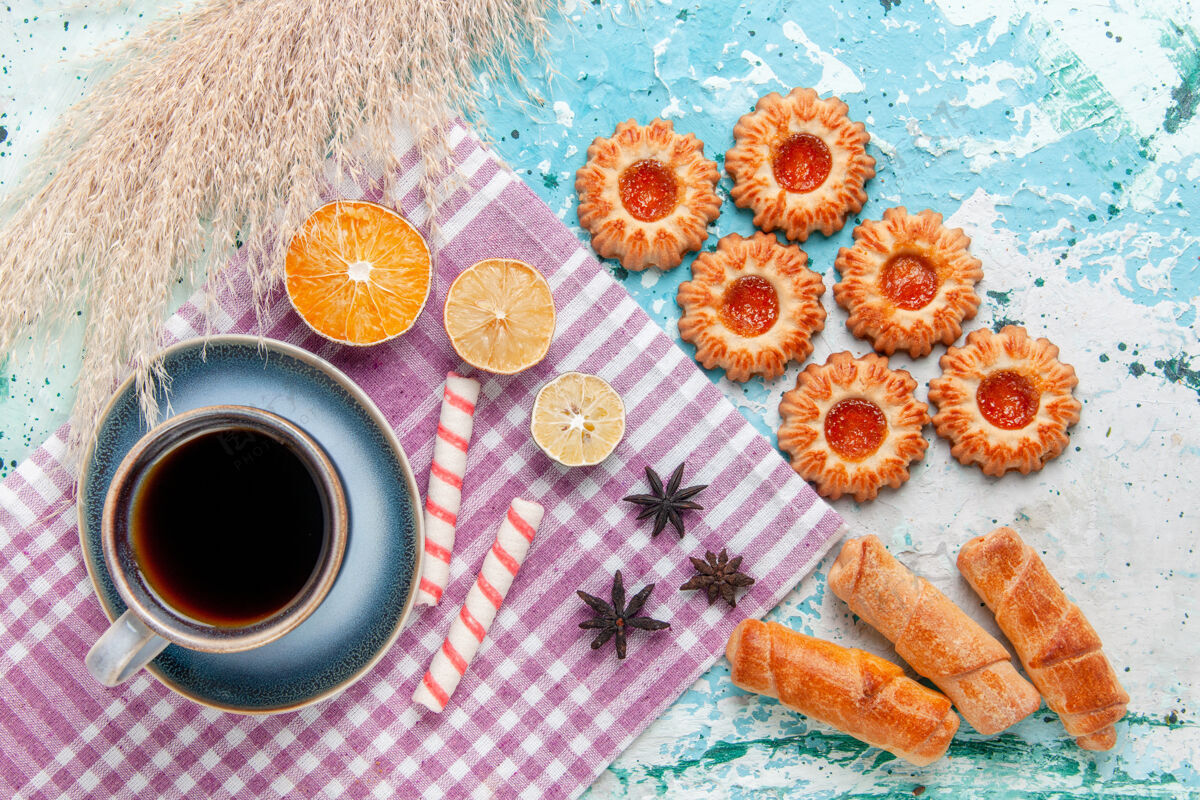 烘焙的商品顶视图一杯咖啡 配百吉饼和饼干 背景为浅蓝色蛋糕 烘焙甜甜的糖派饼干蛋糕蛋糕背景