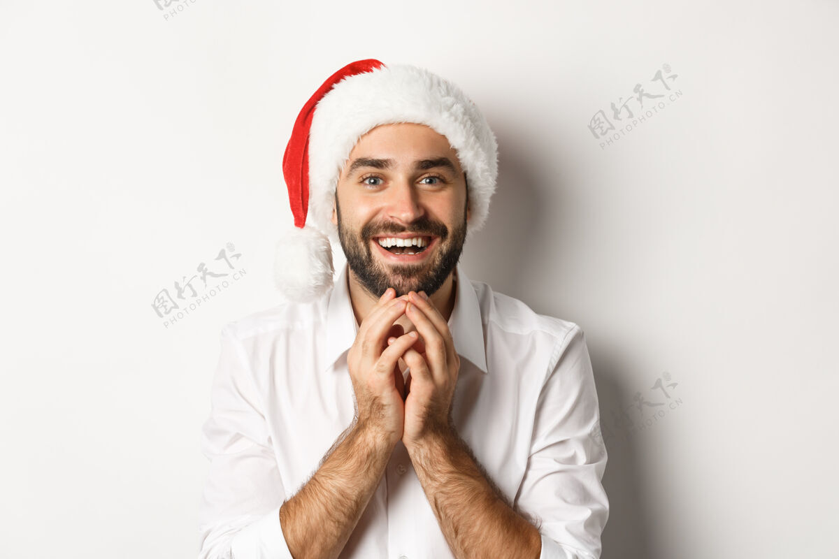 冬天派对 寒假和庆祝的概念兴奋和充满希望的人在圣诞帽期待着惊喜的圣诞礼物帽子情绪化胡须