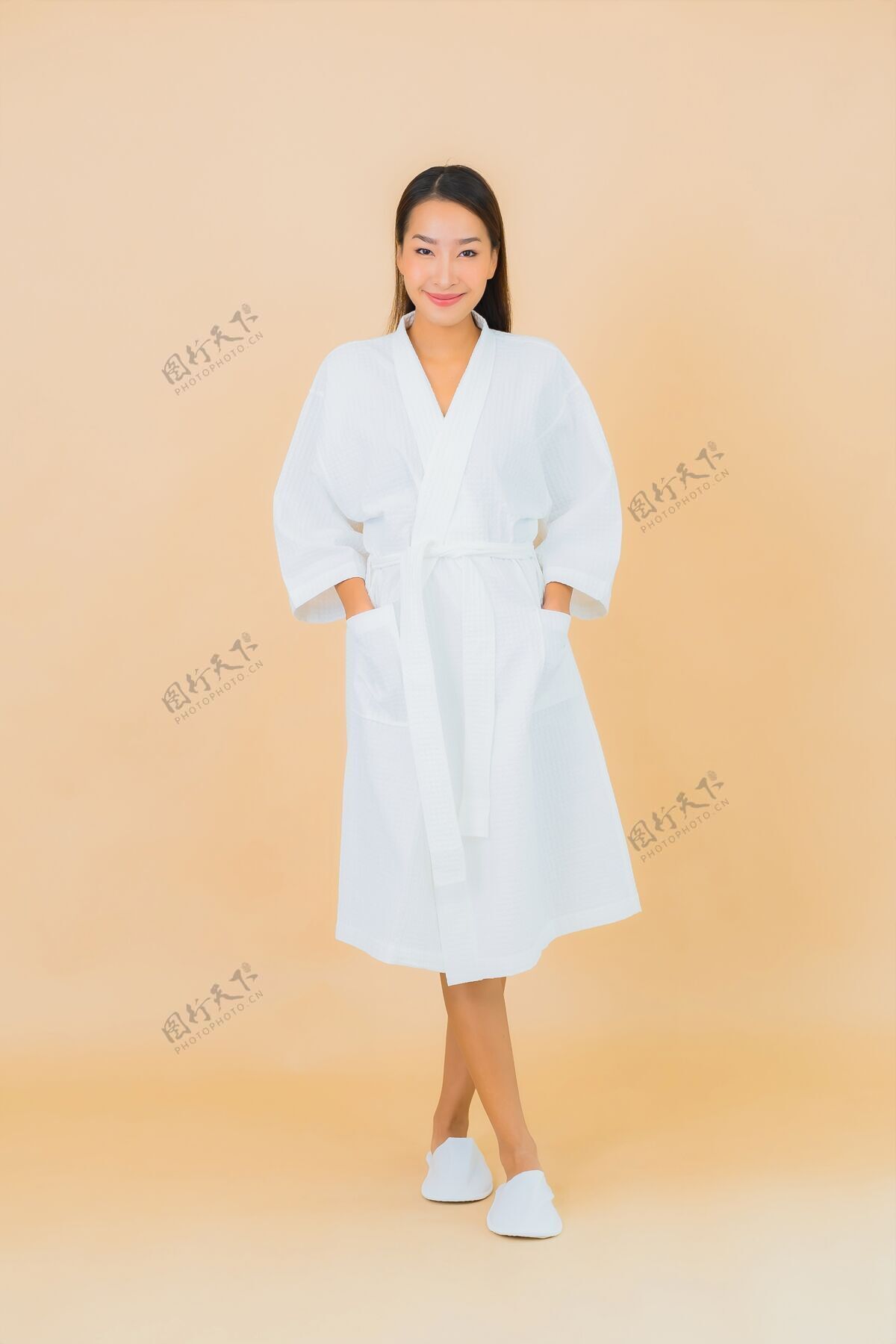 看肖像美丽的亚洲年轻女子穿着米色的微笑浴袍淋浴黑发毛巾