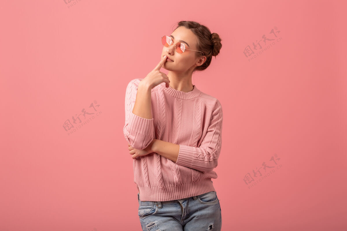 思考年轻漂亮有思想的女人 穿着粉色毛衣 戴着太阳镜 站在粉色工作室的背景下仰望天空开朗体贴怀疑