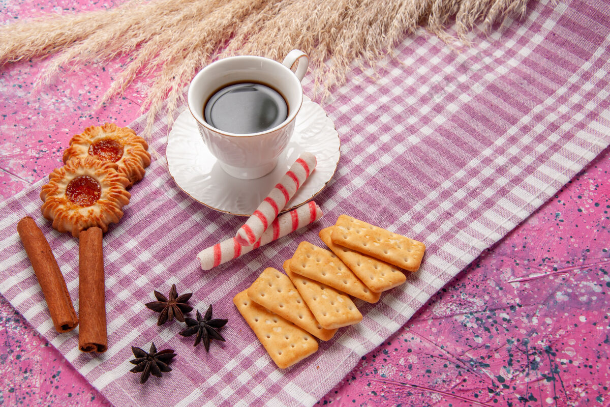 桌子一杯茶加肉桂饼干和饼干放在粉色桌上饼干糖甜烤饼干餐早餐