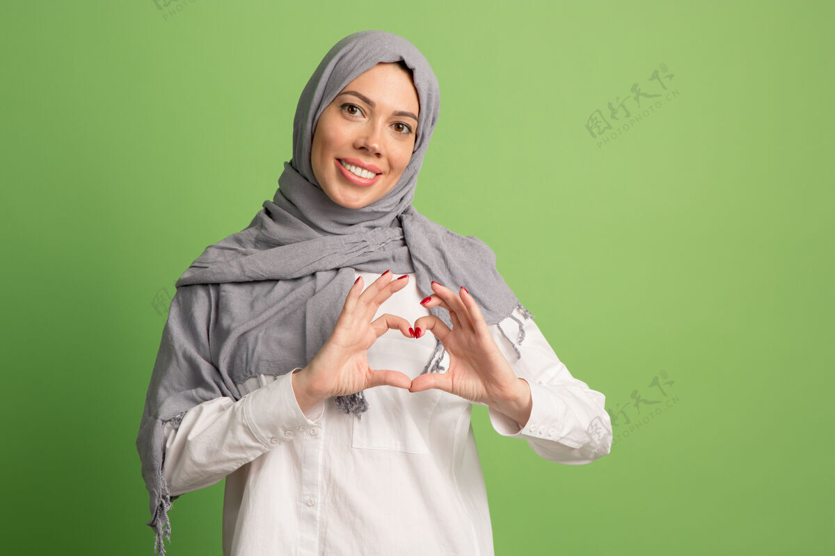 情绪化戴着头巾的快乐阿拉伯女人微笑女孩的肖像 在绿色工作室摆姿势伊斯兰穆斯林围巾