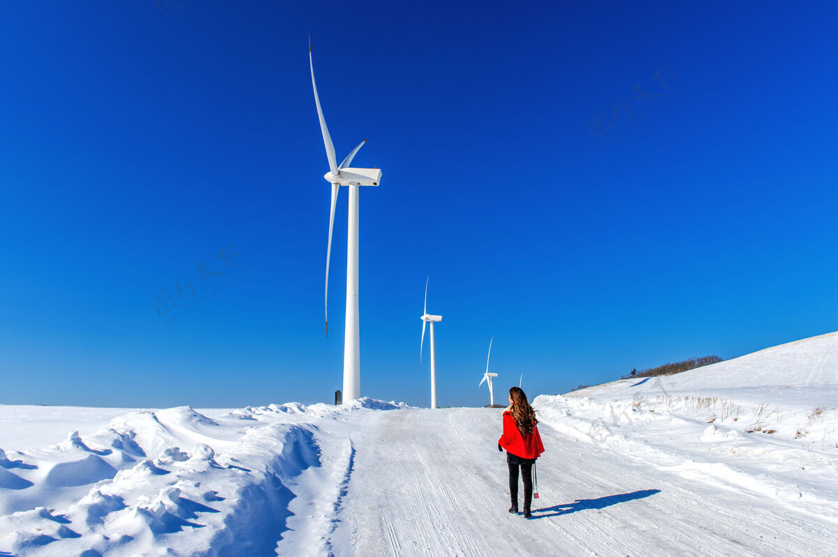 牧场美丽的女孩穿着雪红的衣服和风机 走在冬天的天空和冬天的路上景观绿色国家