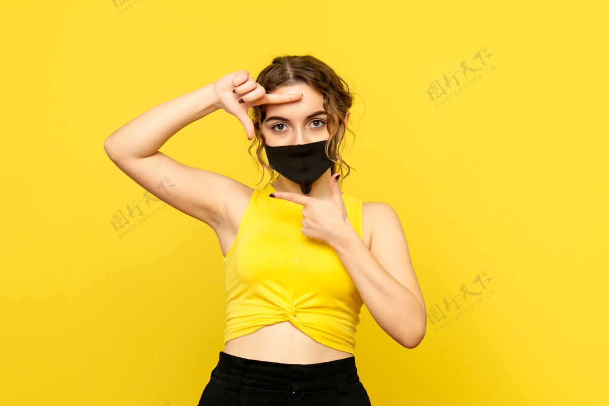 头发黄墙上戴着面具的年轻女子的正视图漂亮年轻流行